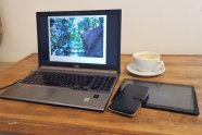 Laptop und Tasse Kaffee auf einem Schreibtisch aus Holz