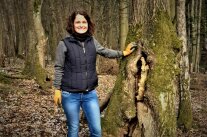 Frau steht neben Baum