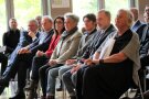 Gruppe von Menschen sitzt in einer Stuhlreihe