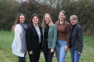 5 Frauen stehen im Freien nebeneinander