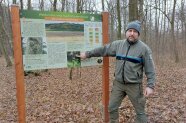 Förster im Wald vor Schild Waldumbauweg