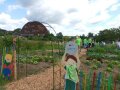 Gartenanlage mit Metallbogen über dem Eingang und Aufschrift "Kinderpflanzgarten"