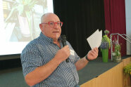 Martin Gramsch hält in einer Hand Zettel, in der anderen Mikrofon