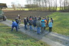 Eine Gruppe von Landwirten steht im Kreis auf einem Feld