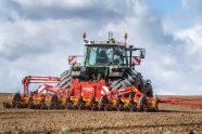 Traktor mit Egge auf einem Feld