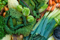 Wirsing, Rosenkohl, Zwiebeln in einem Korb, daneben Lauch Möhren, Petersilie und Rotkohl