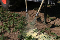 Maschine trägt spritzbares Mulchmaterial am Feld aus.